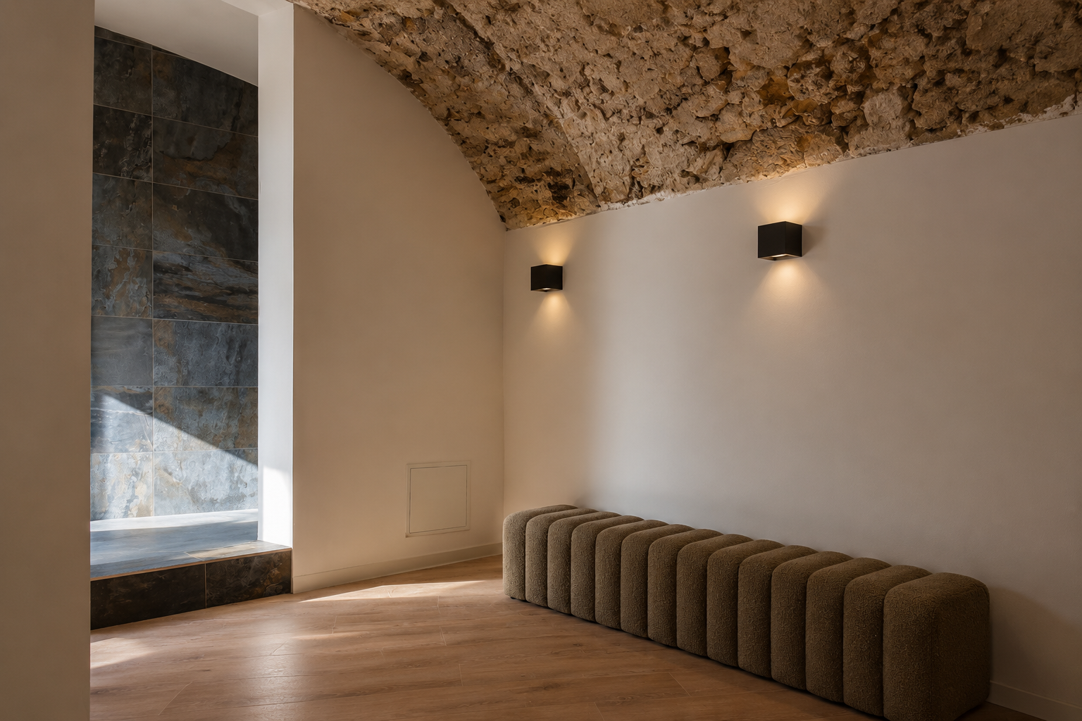 Vue panoramique du studio LOUMA Pilates à Sisteron, voûte en pierre apparente, banquette bouclé olive, mur de pierre slate, sol chêne clair
