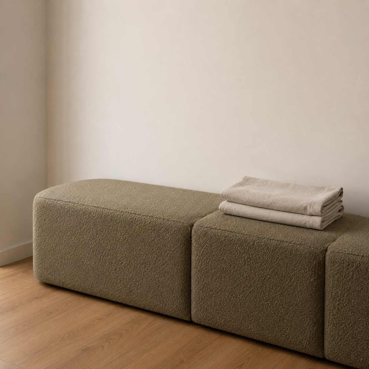 Banquette bouclé olive du vestiaire avec serviettes en lin pliées
